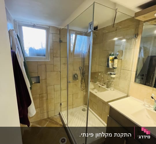 מקלחון זכוכית פינתי מותקן בחדר רחצה